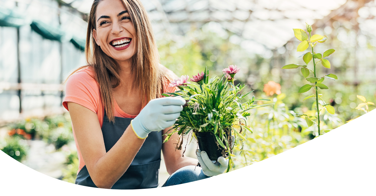 woman smile while gardening in greenhouse
